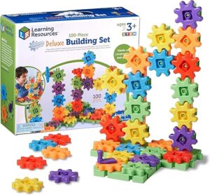 Gears connected together. There is a box set in the background titled "Learning Resources, 100-Piece Deluxe Building Set"