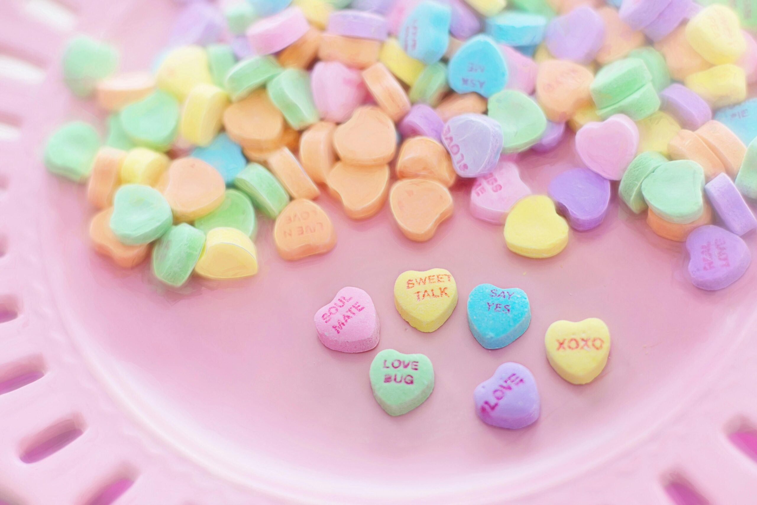 Valentine's Day Candy Hearts on a pink plate.
