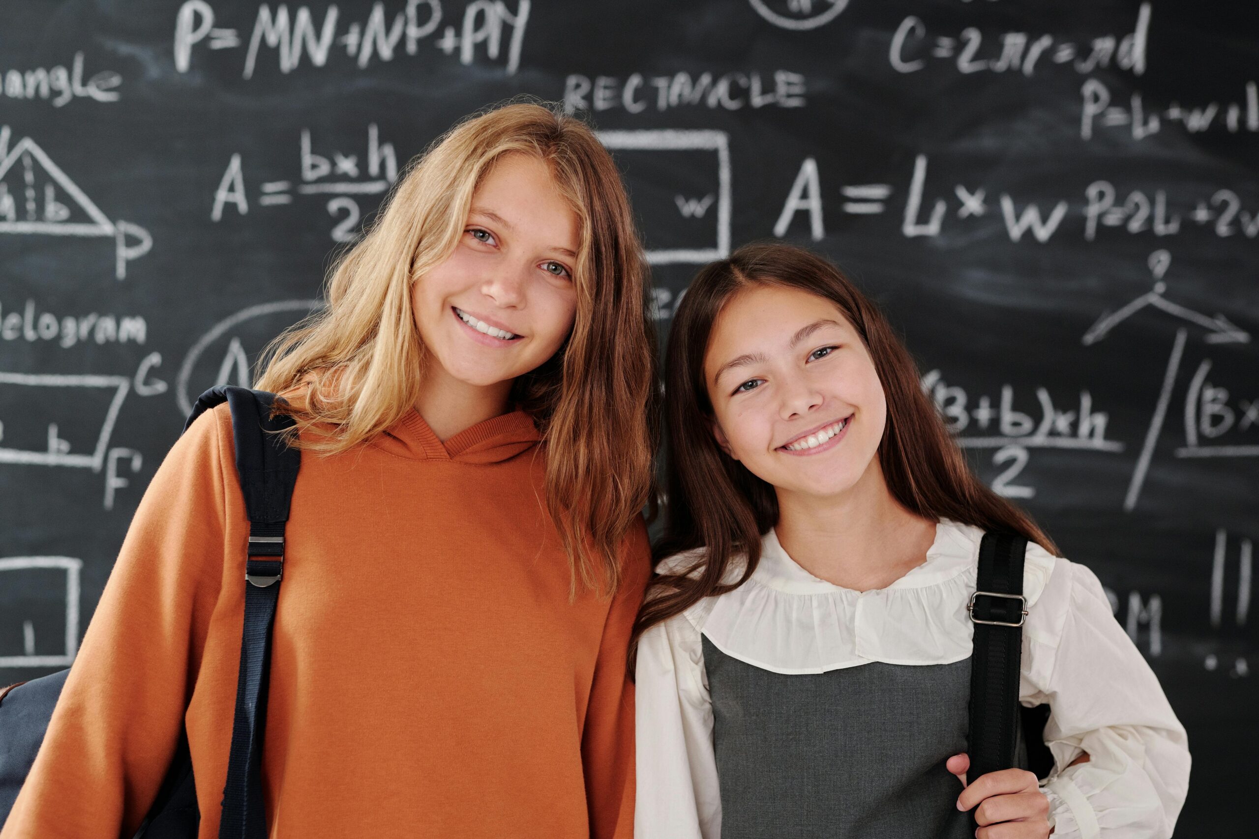 Middle School age students in front of math chalk board