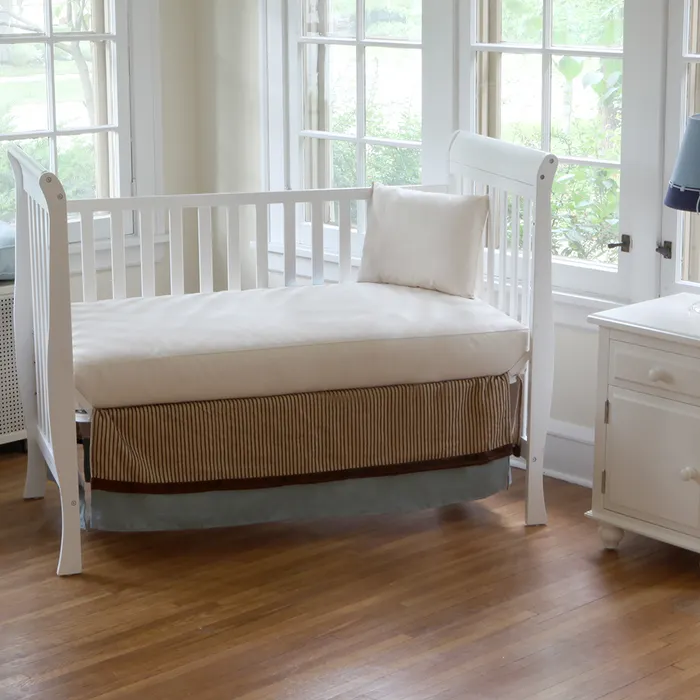 A Naturepedic mattress inside an open crib