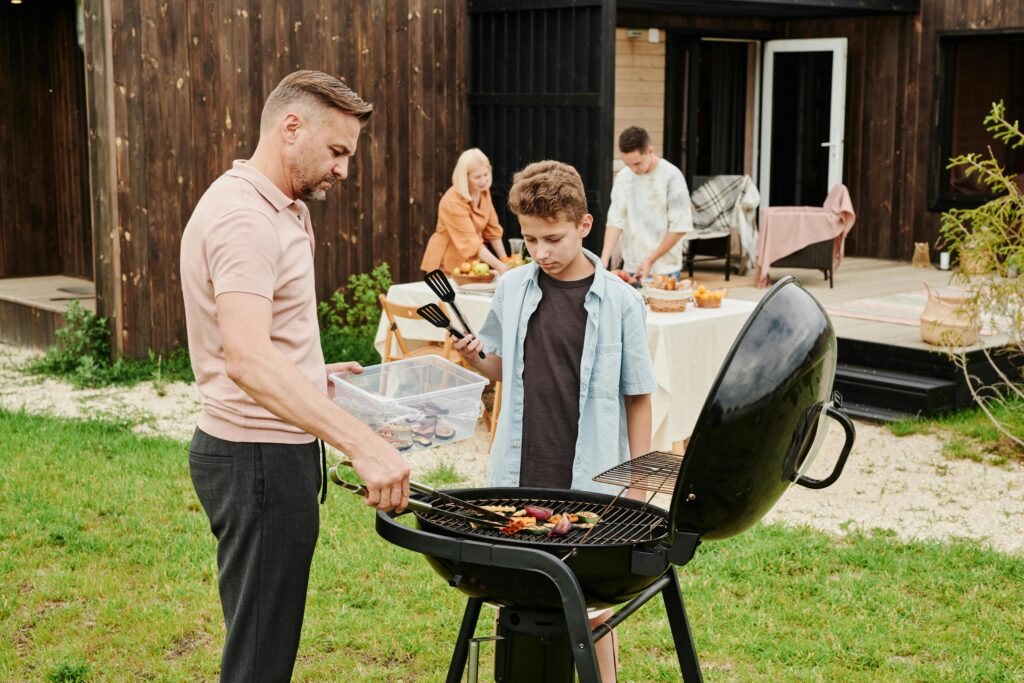 dad and son managing a backyard bbq cookout.