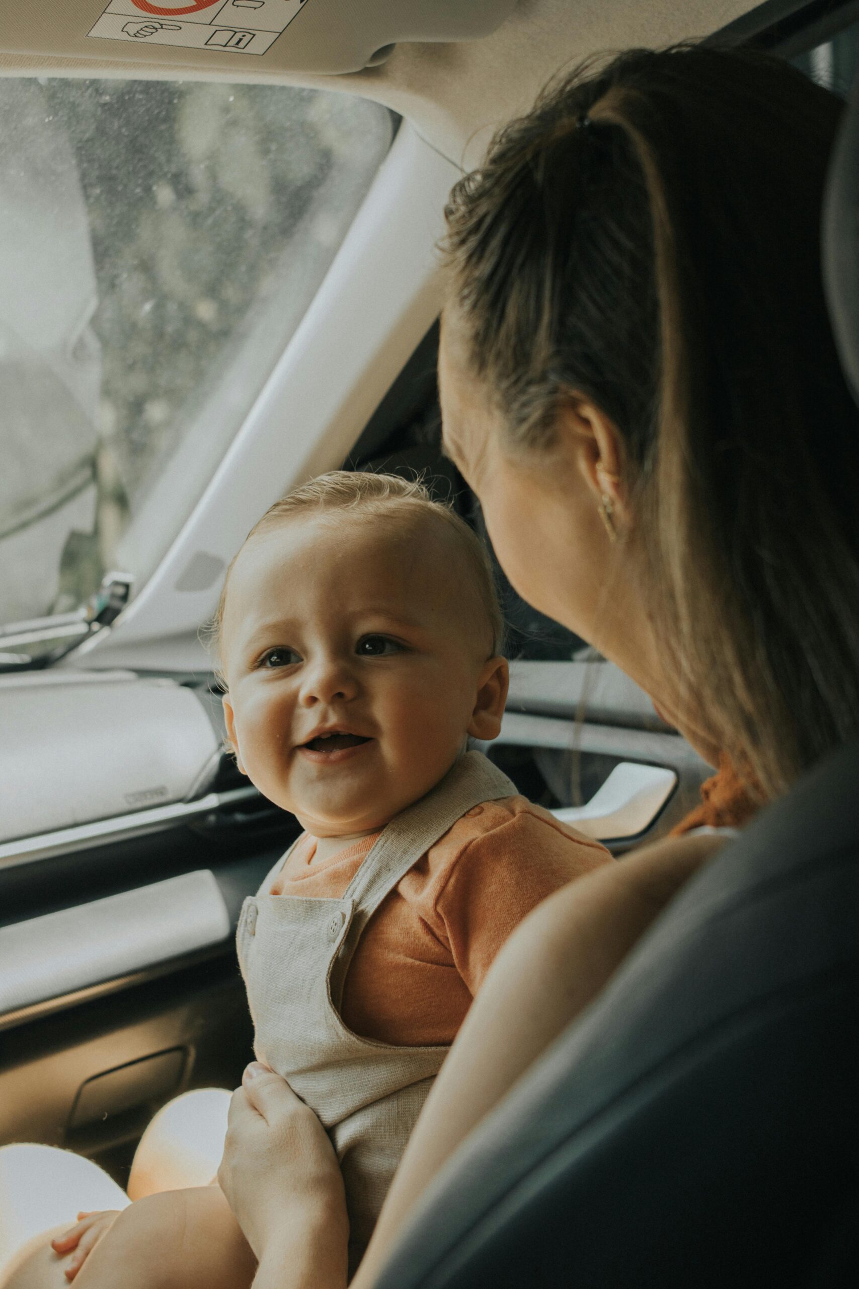 mom and baby sitting in car.