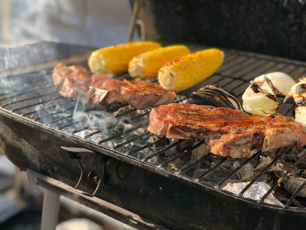 Backyard BBQ, food on grill. Steak and corn.