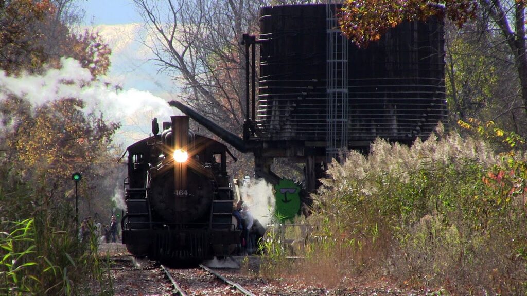 Michigan Halloween train rides — a ghostly lit train running through fall foliage at dusk