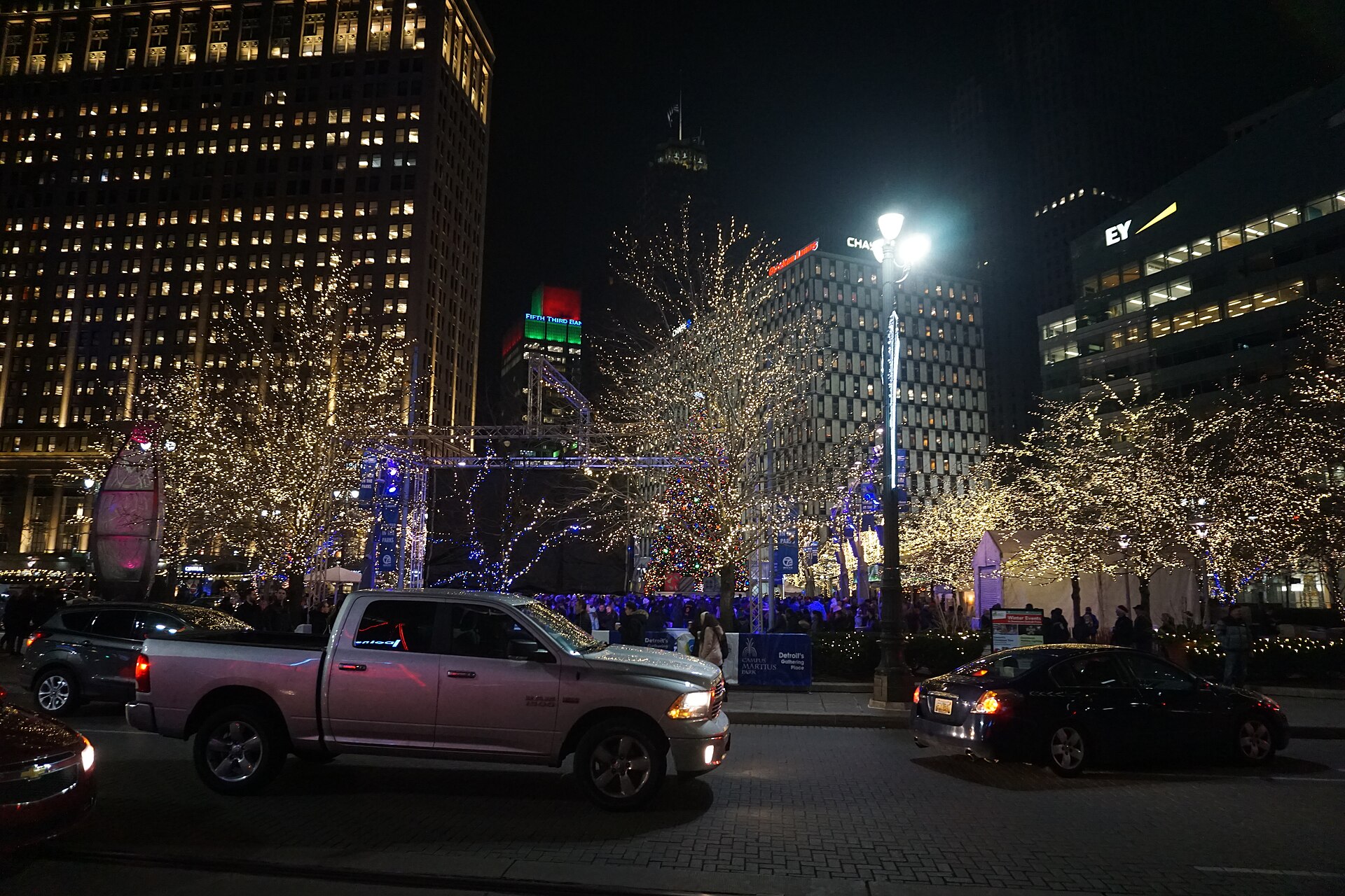 Lit trees and holiday structures at Campus Martius Park in downtown Detroit at night