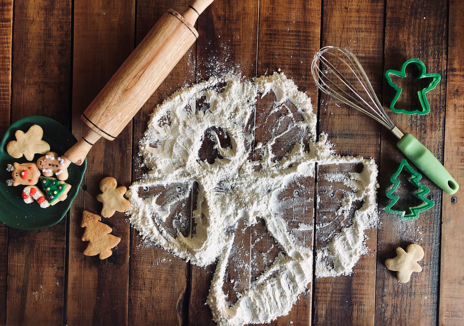 Overhead view of a Christmas cookie baking day with flour, a rolling pin and cookie cutters