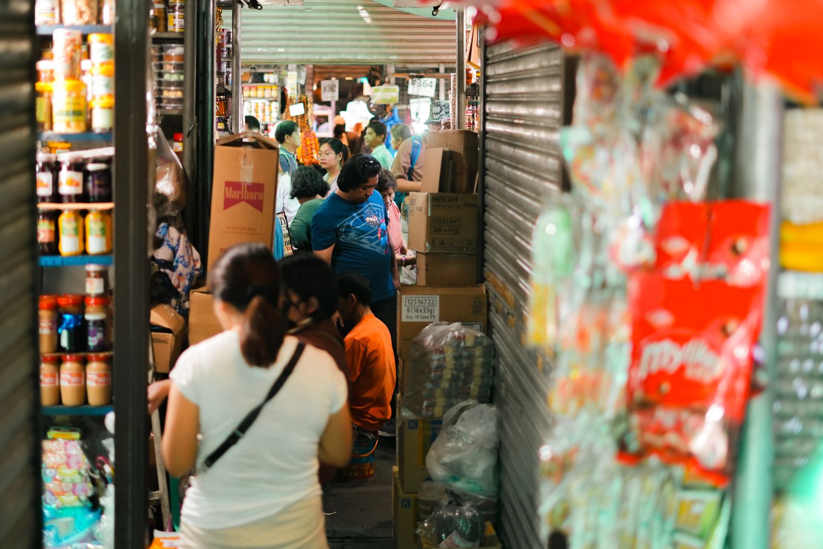 A crowded store aisle with shoppers and fully stocked shelves