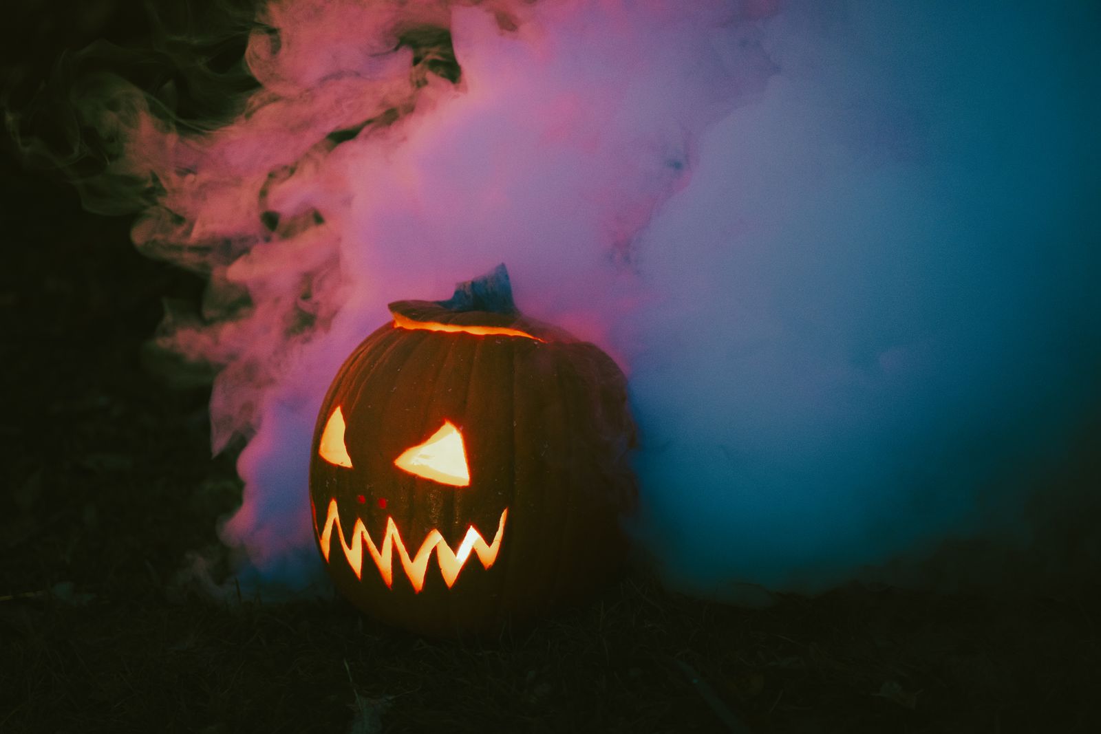 Jack-o-lantern glowing through colored smoke