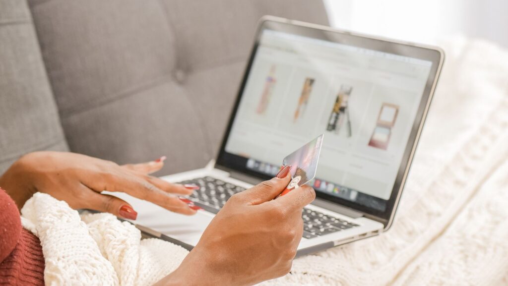 Shopping online on a laptop with a card in hand
