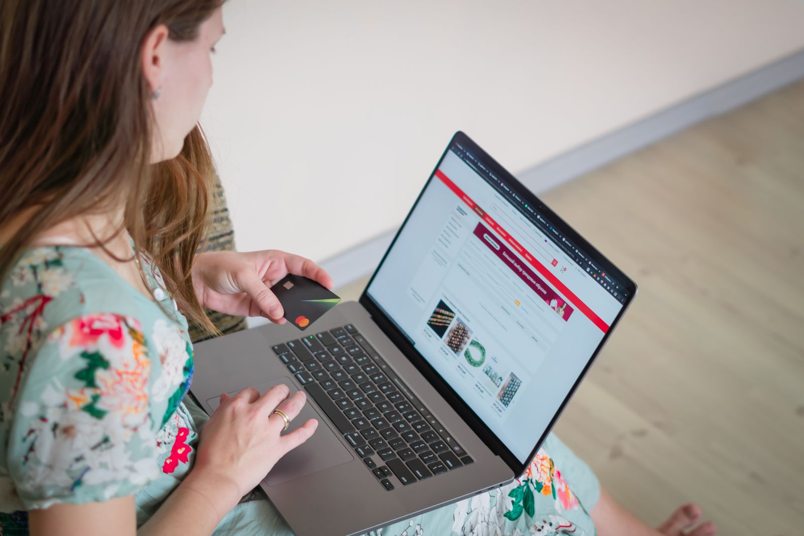 A woman shopping online at home with a laptop and a payment card