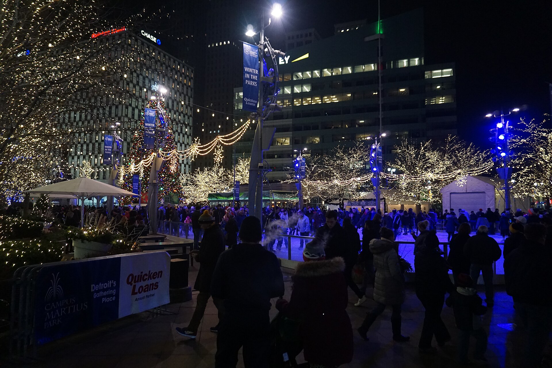 Skaters on the Rink at Campus Martius Park in downtown Detroit under lit trees at night