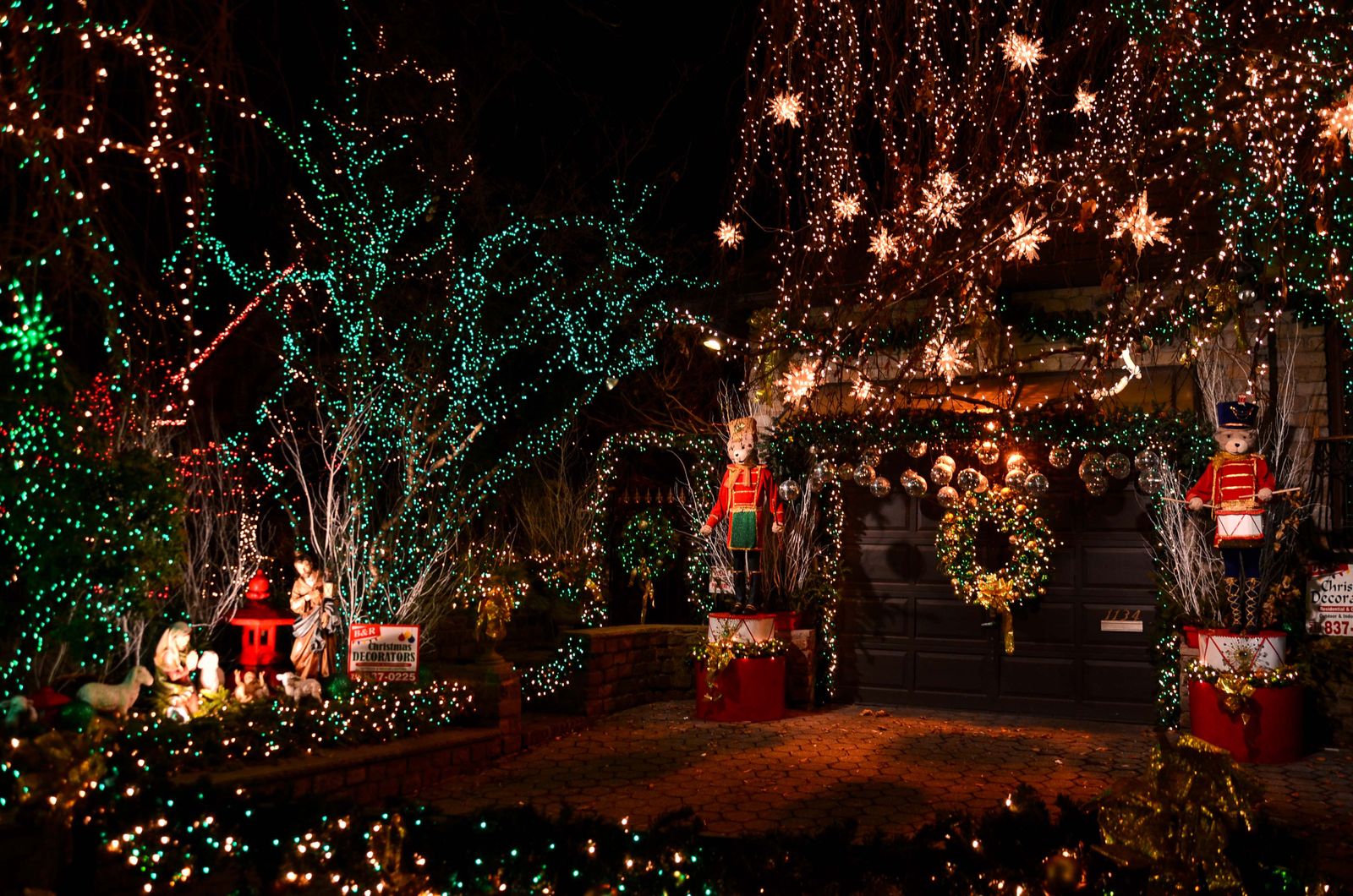 A front yard covered in Christmas lights, wreaths and light-up figures